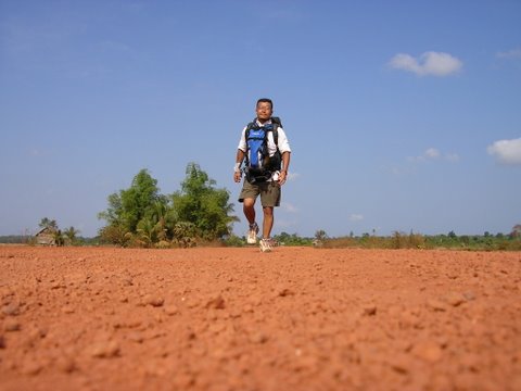 赤土の路面には砂利がゴロゴロしていて歩きにくい。国道48号線で。