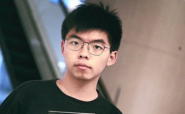 1280px-Joshua_Wong_holds_Honcques_Laus's_book