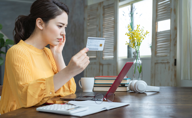 Attractive asian woman using a credit card. Online shopping.
