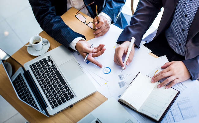 Business,Team,Hands,At,Working,With,Plan,On,Office,Desk