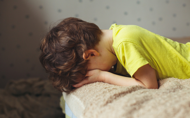 Tired,Toddler,Boy,Lying,On,The,Bed,With,His,Face