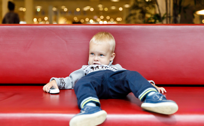 Child,Is,Lying,On,The,Couch,In,The,Shopping,Center