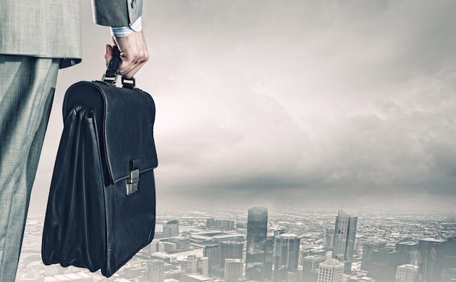 Back,View,Of,Businessman,With,Suitcase,Looking,At,City