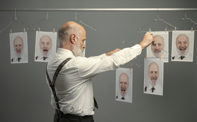 Mature,Businessman,Staring,At,His,Different,Personalities,On,A,Collection