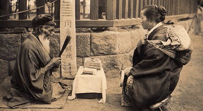 1280px-Fortune_Teller_on_the_street_of_Japan_(1914_by_Elstner_Hilton)