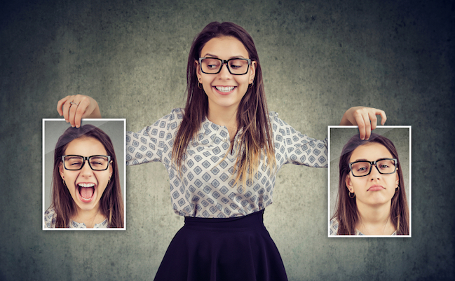 Happy,Woman,Holding,Two,Different,Face,Emotion,Masks,Of,Herself
