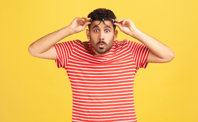 Overwhelmed,Bemused,Man,With,Beard,In,Striped,T-shirt,Raising,Eyeglasses