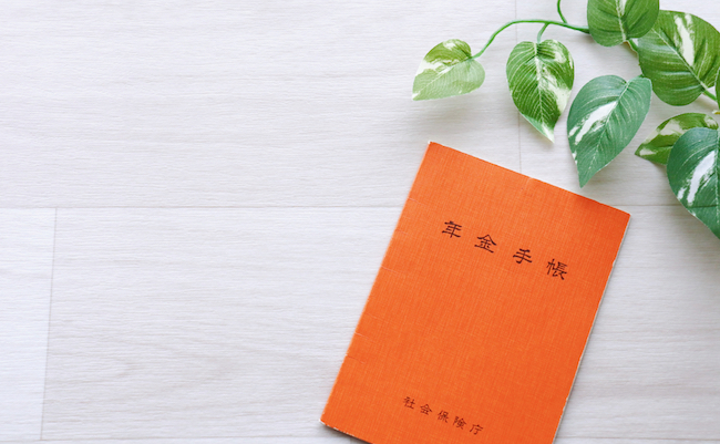 Japan’s,Orange,Pension,Book,Is,On,A,White,Wooden,Table.
