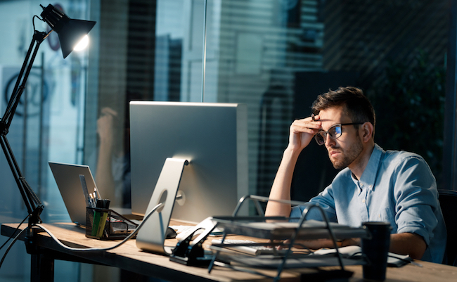 Casual,Tired,Office,Worker,Sitting,At,Desk,Using,Computer,And