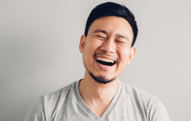 Headshot,Photo,Of,Asian,Man,With,Laugh,Face.,On,Grey