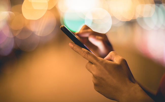 Hands,Using,Smartphone,On,Night,City