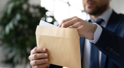 Close,Up,Businessman,Wearing,Suit,Holding,Opening,Paper,Envelope,With