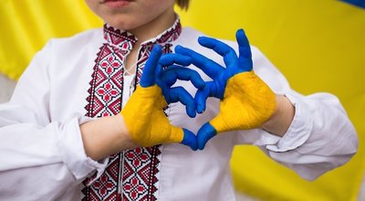 Children against war. Russia's invasion of Ukraine, request for help from world community. child against background of Ukrainian flag with hands in shape of a heart, painted in yellow and blue