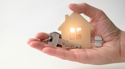a woman's hand holds a model of a wooden house and keys. the concept of buying, selling, renting real estate. Home insurance, mortgage purchase, lending for the purchase of real estate.