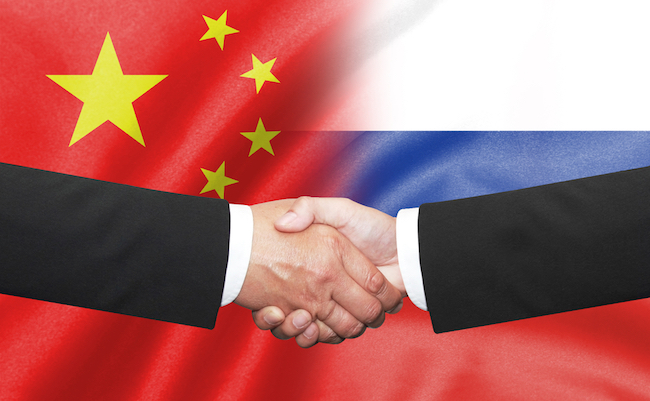 two business man shakehand on china and russian flag