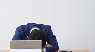 Tired asian businessman in office.