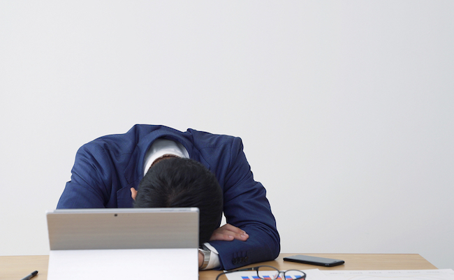 Tired asian businessman in office.
