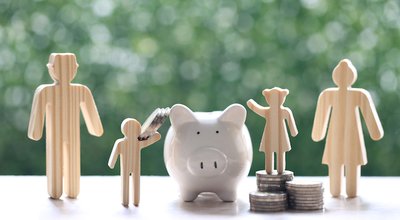 Model family with piggy bank and stack of coins money on natural green background,Save money for prepare in future and family finance concept