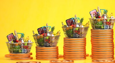 Growth of food sales or growth of market basket or consumer price index concept. Shopping basket with foods with coin stacks on yellow background. 3d illustration