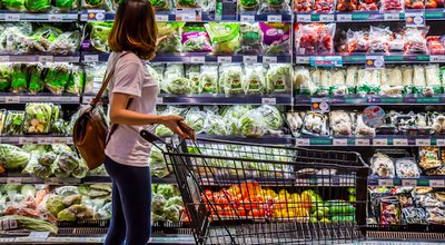 Rayong , Thailand - April 1 , 2018 : A woman is looking for organic vegetable in the shelf at TOP supermarket. Local fresh vegetable is good for healthy people