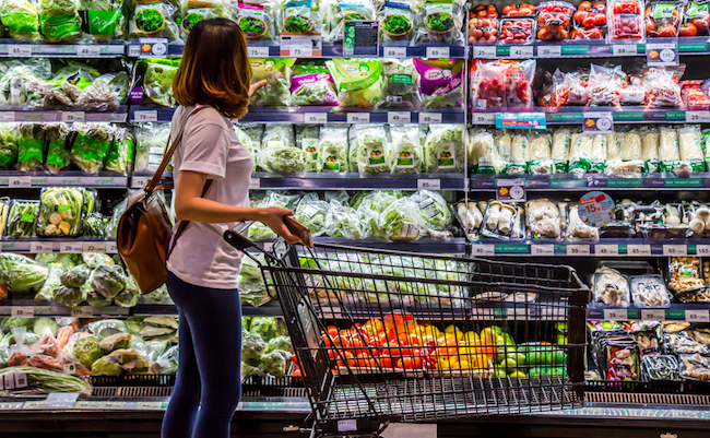 Rayong , Thailand - April 1 , 2018 : A woman is looking for organic vegetable in the shelf at TOP supermarket. Local fresh vegetable is good for healthy people