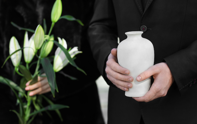Couple,With,Mortuary,Urn,And,Flowers,At,Funeral