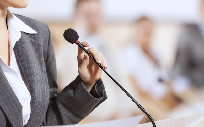 Businesswoman,Standing,On,Stage,And,Reporting,For,Audience