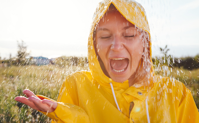 Unhappy Woman In Rain Wearing Waterproof Coat At Outdoor Music Festival