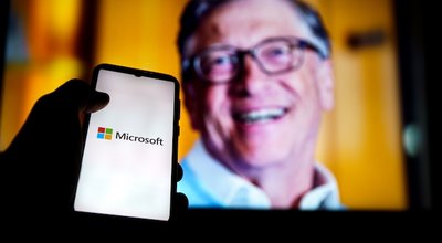 Kaunas, Lithuania 2022 - April 20: Microsoft logo on screen and Bill Gates in a background. He is a co-founder of Microsoft