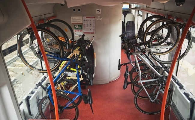05.29.2022 Gdansk Poland. Six bicycles are hanging on a bike rack in public transport. Bikes are mounted for transportation. Concept of commuting on a train with a bike.