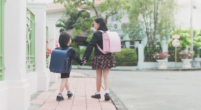 Cute Asian children  holding hand  together while  going to the school outdoors,Back to school concept