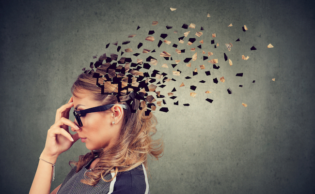 Memory loss due to dementia or brain damage. Side profile of a woman losing parts of head as symbol of decreased mind function.