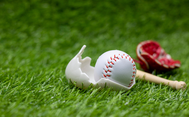 Baseball is in egg shell for Easter Holiday on green grass