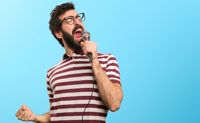 Man,With,Glasses,Singing,With,Microphone,On,Colorful,Background