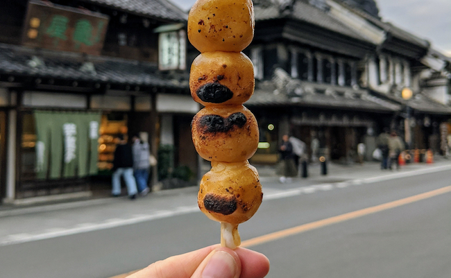 Dango is a classic Japanese street food. The dumplings are made from rice flour dough, grilled and topped with sauce or bean paste. Taken in the historic town of Little Edo, Kawagoe, Saitama, Japan.