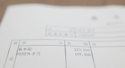 Pay slip written in Japanese. Description of overtime charges. Translation: Wages. item. Amount of money. Basic salary. Overtime allowance.