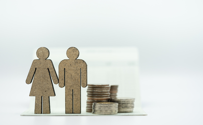 Wooden couple icon and coins stack on bankbook on white background. Concept of money saving, financial, personal loan,retirement,insurance.