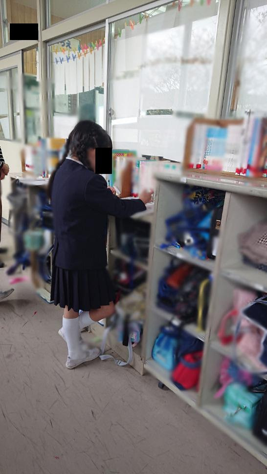 Aさんとガラスに紙を貼られてその隙間から授業を受ける様子=Aさん家族提供