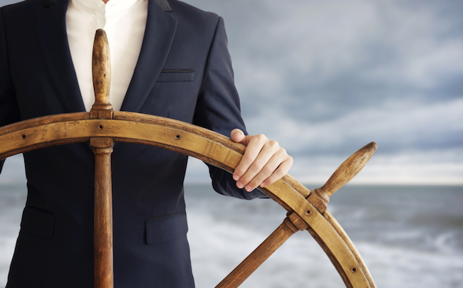 Businessman,Holding,Ship,Wheel,And,Navigates,In,Storm.