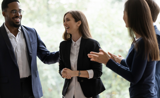 Happy diverse business team applauding coworker success. Employees congratulating promoted colleague, expressing gratitude, recognition, appreciation for good job result, work achieve