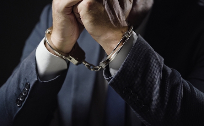 Businessman,In,Handcuffs,Arrested,For,Financial,Fraud,,Sitting,In,Interrogation