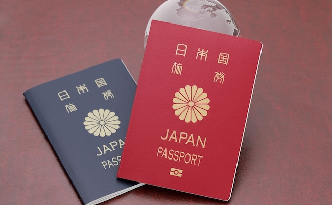 Japanese passport with glass globe on red leather background