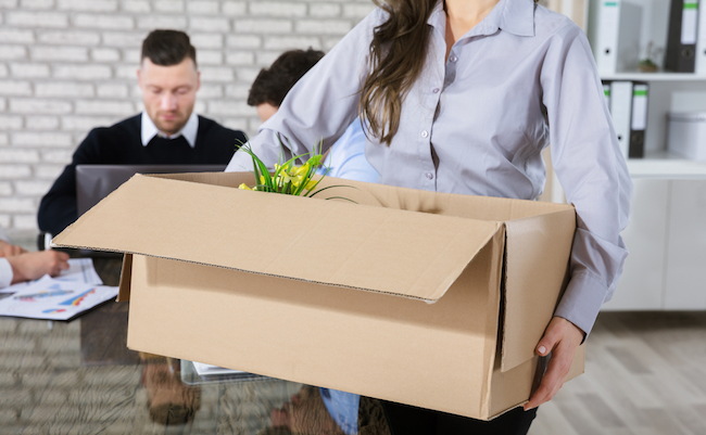 Fired Businesswoman Leaving Office With Her Belongings In Box