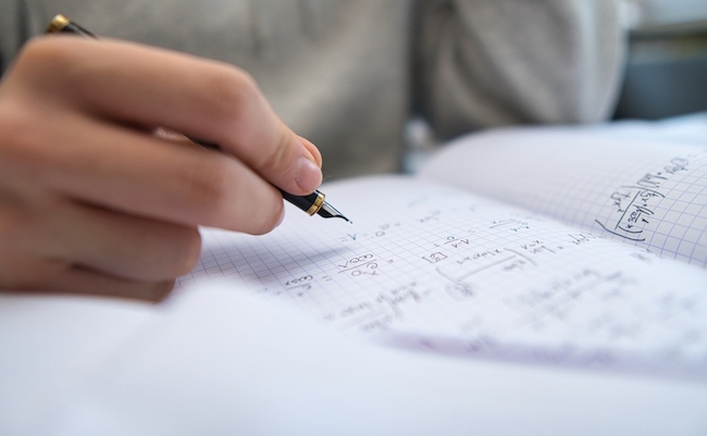 Bielsko, Poland - 12.10.2021: the student learns math on his own at home. Preparation for an important exam by solving math problems