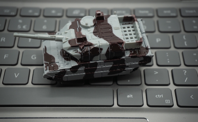 Computer keyboard with tanks on it. An allusion to cyber warfare.concept of cyber attacks.