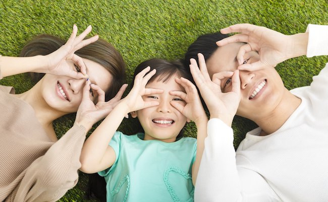 top view of Happy  Young  Family lying on the grass