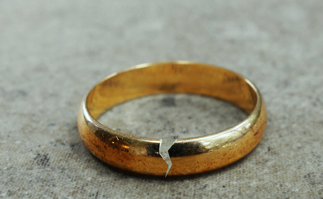 Cracked gold wedding ring -- divorce or infidelity concept