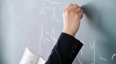 A,Japanese,Woman,Teacher,Writes,On,The,Blackboard,In,Her