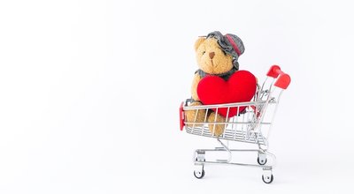 Little bear holding red heart in shopping cart with space on white background, valentine sale, love and romance, relationship