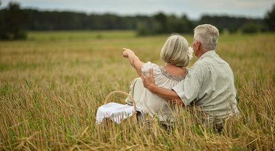 Senior couple on mowed field of wheat
